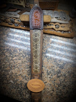 Buffalo leather rifle slings with tooled upper and rattlesnake inlay.